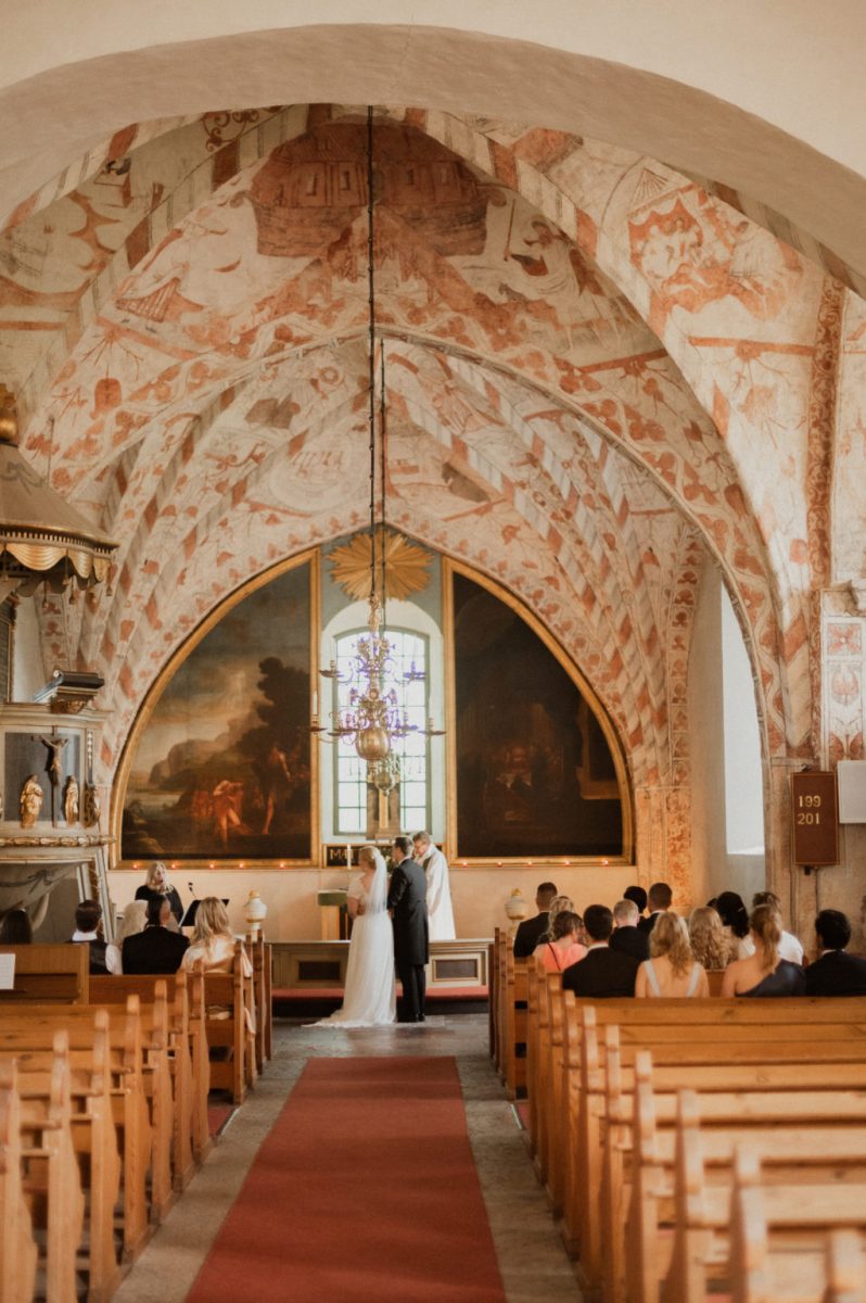 Brudparet står framme vid altaret, Fotograf JD
