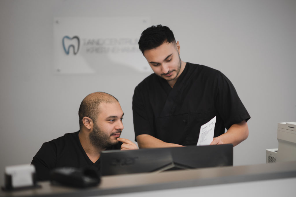Två tandläkare står och kollar i en journal, Fotograf JD
