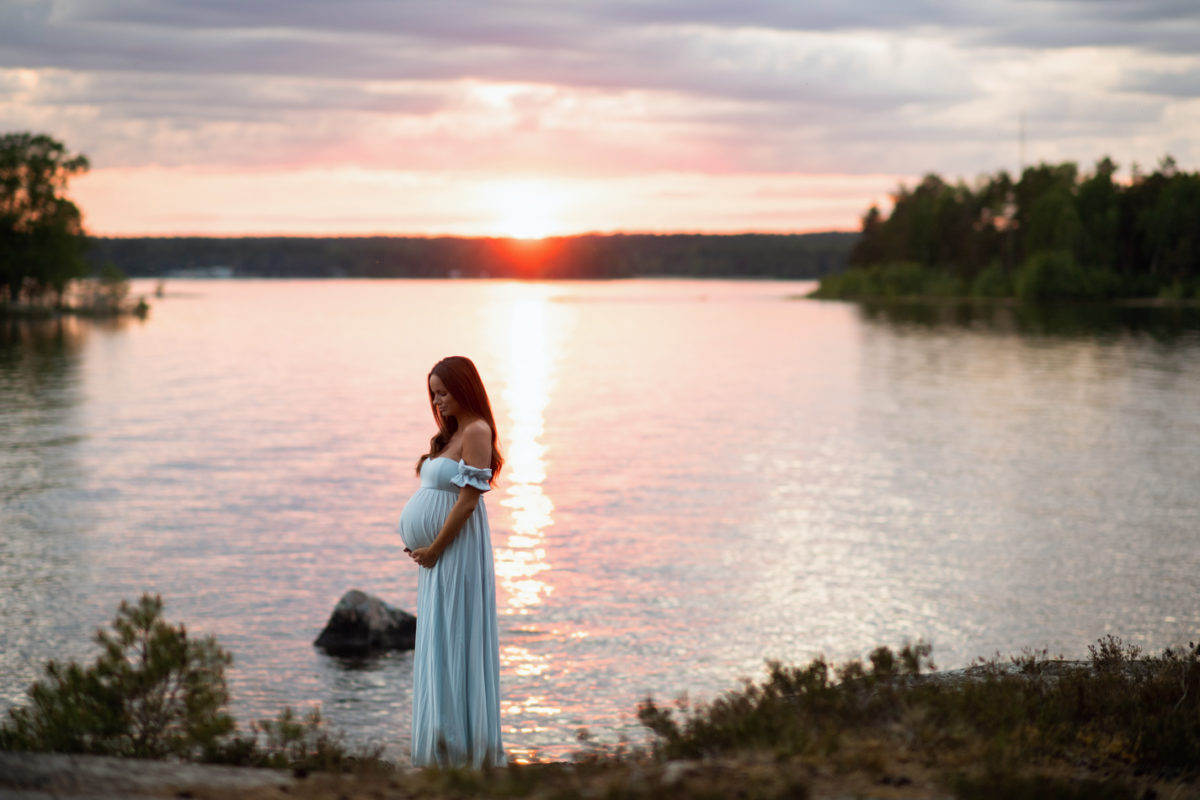Porträtt gravid kvinna i solnedgången vid vattnet, Fotograf JD